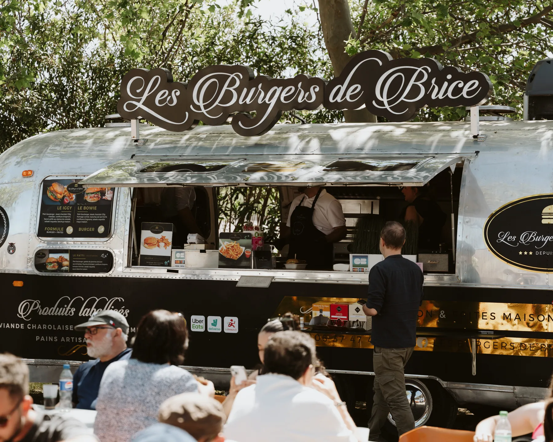 L'Airstream des Burgers de Brice entouré de clients attablés en plein air